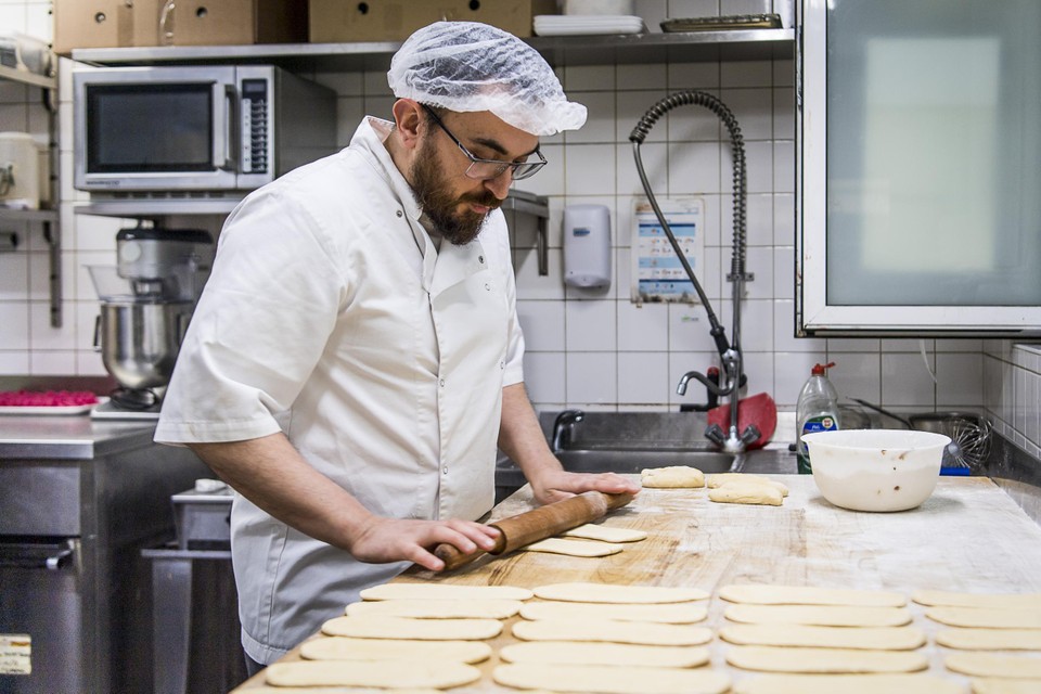 Yousef Raoui (47) werkt aan het deeg van de kaaskoeken. “Ik werk al 15 jaar met veel plezier in deze bakkerij.”