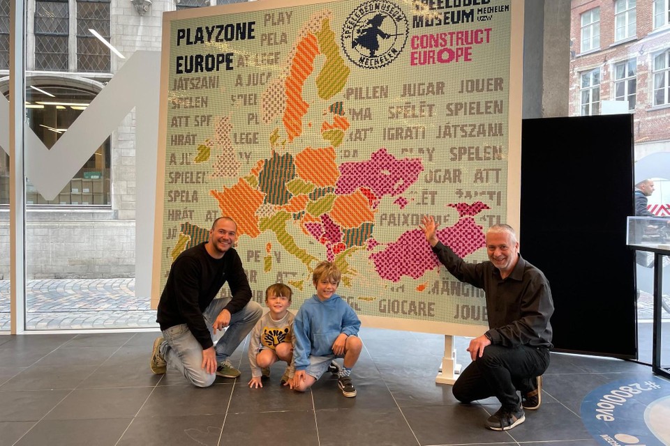 Directeur Niek De Meester, kunstenaar Hans Demol en twee jonge Lego-liefhebbers bij de grote landkaart.