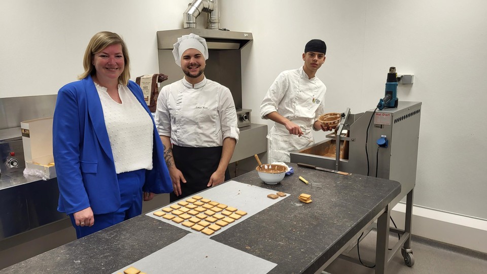 Adjunct-directeur Karen Celis met enkele Italiaanse leerlingen, die momenteel in de Geelse Hotelschool les lopen, bij het maken van koekjes met chocolade.