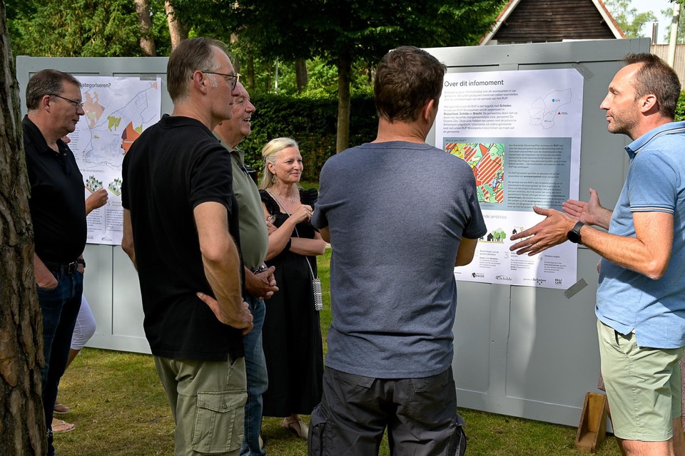 Schepen Paul De Swaef (l) luistert samen met bewoners van Schotenhof en De Zeurt naar de toelichting over de toekomstige bouwregels voor de woonparken. 