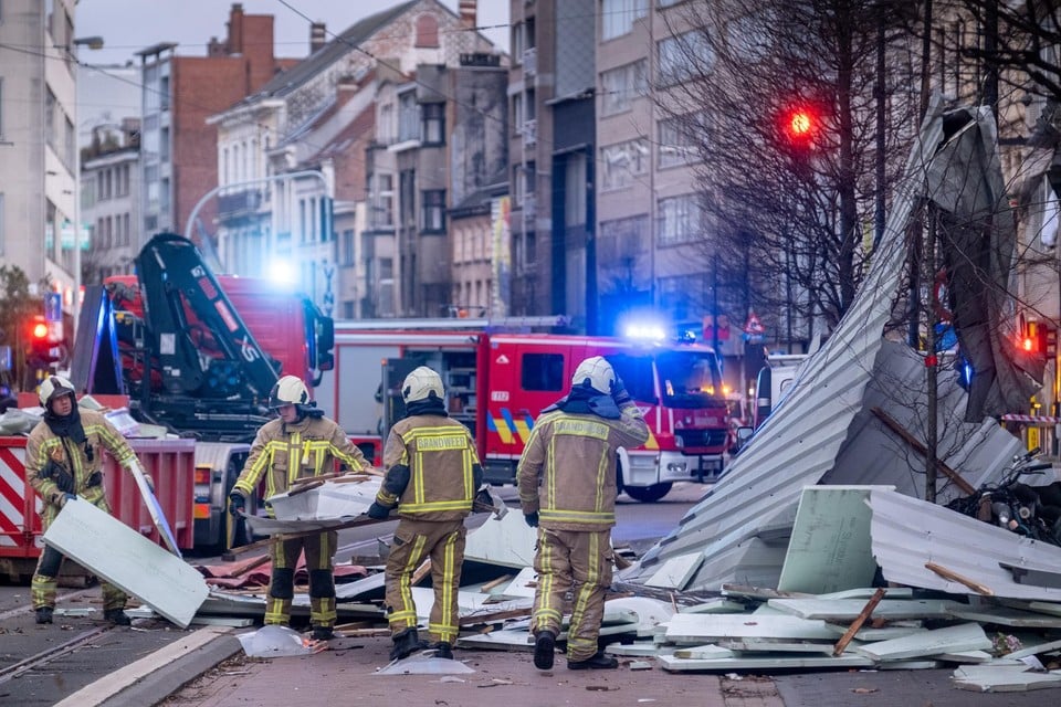 Brandweermannen ruimen puin op de Turnhoutsebaan in Antwerpen. 