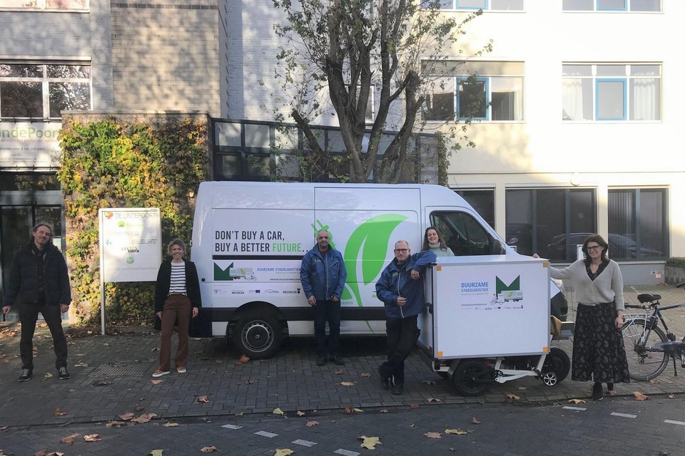 Een elektrische bestelwagen parkeert aan De Lindepoort. Daar nemen fietskoeriers het over.