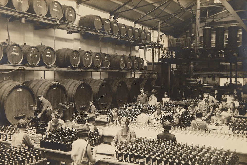 Medewerkers vullen en controleren de flessen met elixir. De foto dateert van het begin van de vorige eeuw. 