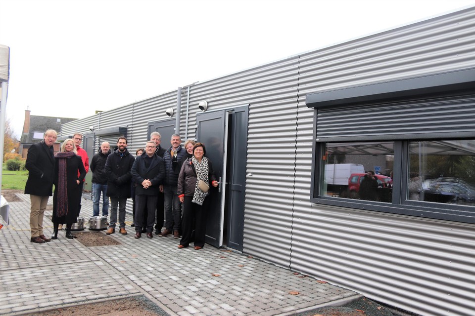 Enkele buren met een aantal leden van het schepencollege bij de drie nieuwe noodwoningen in Breendonk. 