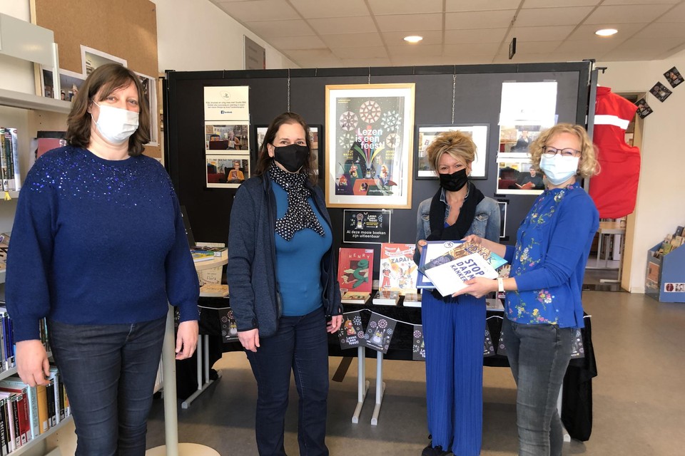 Bibliothecaris Katleen Van Eecke en schepen Elke Tweepenninckx nemen boeken in ontvangst van Kim Ooms en Elke Tegenbos van Olen tegen Kanker.