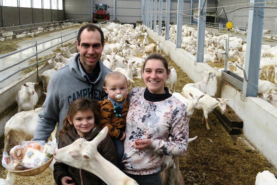 Els, Tom, Silke en Bram bij hun kudde van voorlopig nog achthonderd dieren. In het mandje hebben ze een assortiment producten die collega-geitenhoeders artisanaal produceren met geitenzuivel.