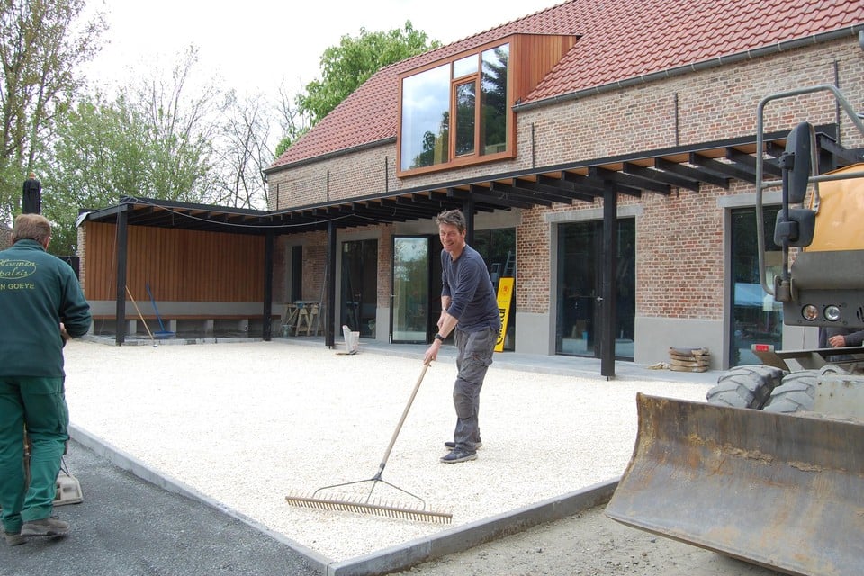 Kris legt eigenhandig het terras aan, dat zaterdag klaar moet staan.