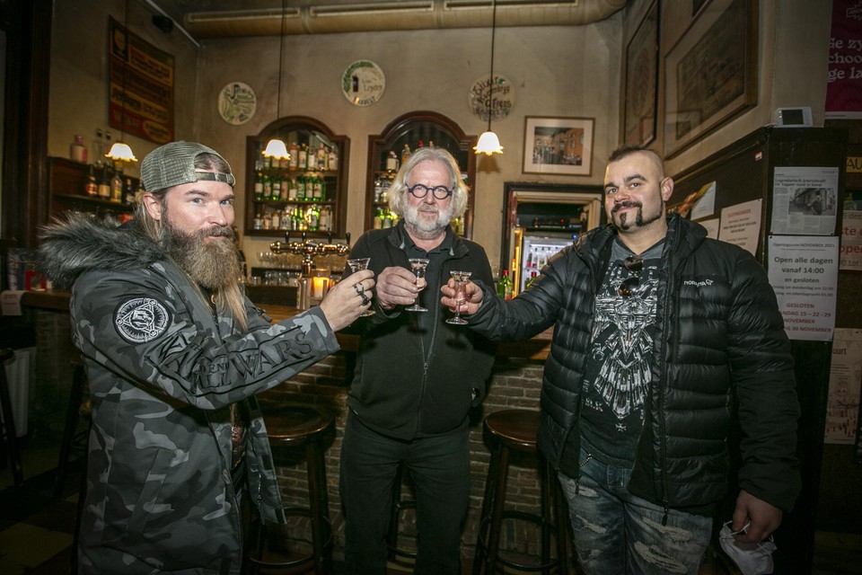 Pär Sundström (links) en Joakim Brodén (rechts) drinken een jenever met Ronald Ferket, de uitbater van café De Vagant in Antwerpen. 