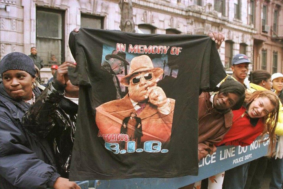 Fans houden een t-shirt vast ter nagedachtenis van de rapper. 