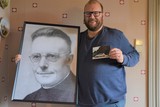 thumbnail: Kevin Verboven met een portret van Jef Bogaerts en de prentbriefkaart die hij in de Massenhovense brievenbussen verspreidde.