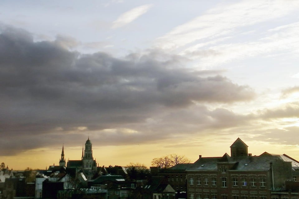 De wolken schuiven open boven de stad Lier.