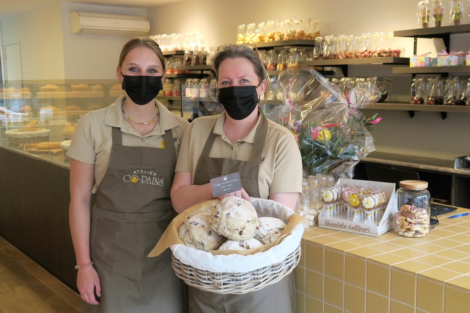 Karin Brughmans toont één van de succesnummers van de pas geopende bakkerij Atelier Co-Pains in ‘s-Gravenwezel: een mand vol ‘roggeverdommekes’. Naast haar winkelmeisje Hanne Van Uffelen.