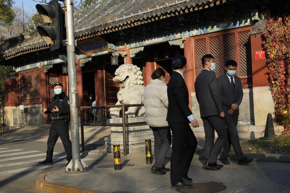 Een agent bewaakt de ingang van de universiteit in Peking, waar één coronageval werd vastgesteld. 