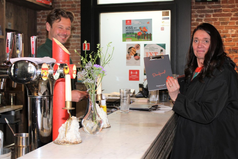 Schepen Ilse Lambrechts overhandigt enkele rekeninghouders aan Kristof Van Humskerken, cafébaas van ’t Kafaat.