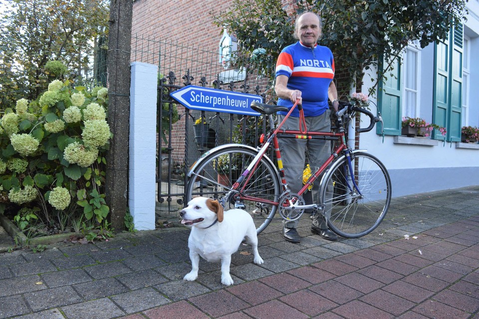 Walter Verheyen met zijn hond Bobby aan zijn huis waar een wegwijzer naar Scherpenheuvel hangt. Op deze retrofiets trapt hij zaterdag de 6.000ste keer naar Scherpenheuvel.  