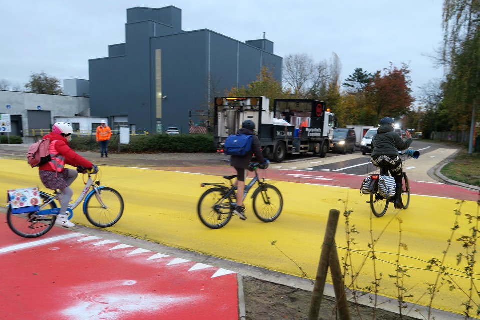 Een mama en haar twee kinderen gebruiken als drie van de eersten het nieuwe gele kruispunt van de Sluizenstraat om de Geuzenveldenstraat in te rijden. 