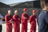 thumbnail: De instructeurs dragen rode overalls. 