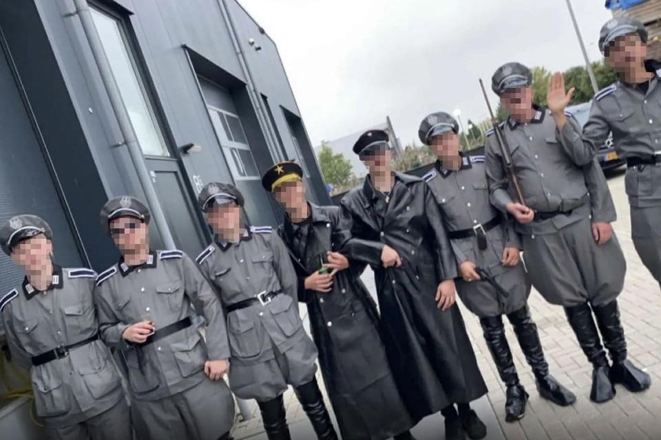 De bende, sommigen met Hitlersnorretje, anderen verkleed als Gestapo, op stap in Urk.