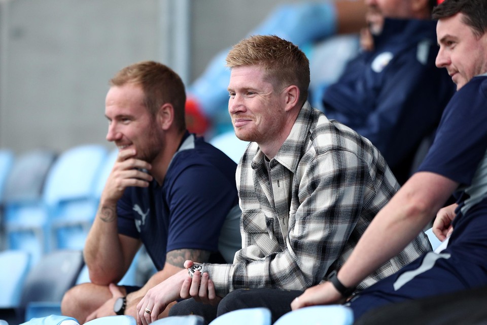 Een goedlachse Kevin De Bruyne woont vanop de tribune een oefenmatch bij tegen Barnsley