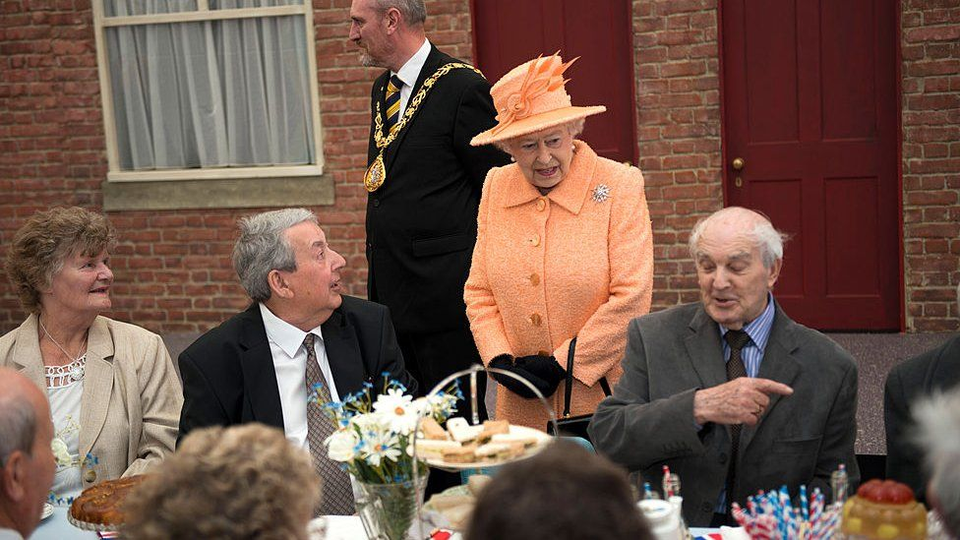 The Queen greets some partygoers on the street in 2012. 