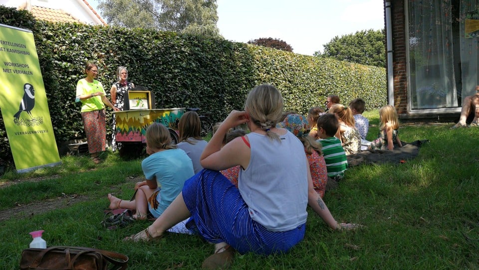 Bij kamishibaiverhalen schuiven de vertellers een reeks prenten een voor een uit het verhalentheatertje weg.