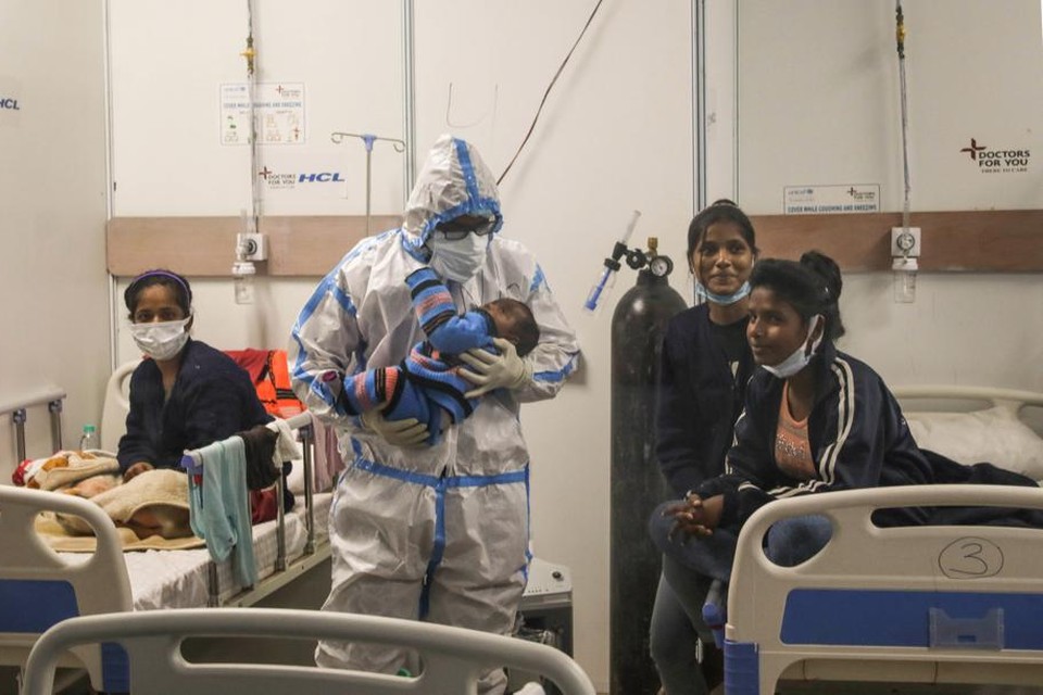 Een verpleeg­kundige ontfermt zich over een besmet kind in New Delhi. 