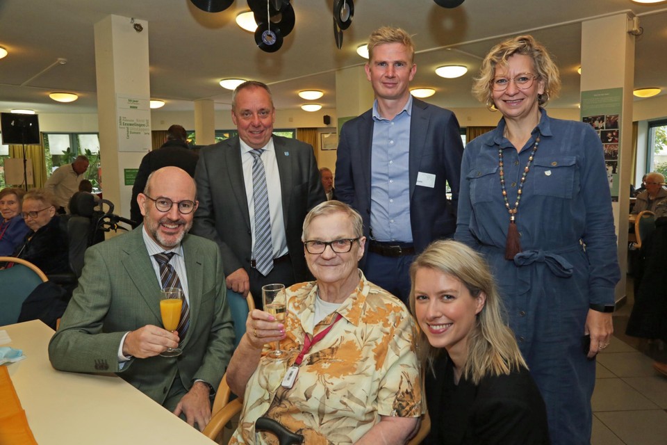 Wieske Geyskens kwam als jong meisje werken in Hof De Beuken. Nu woont ze daar. Op de foto samen met schepen Els Van Doesburg, districtsburgemeester Koen Palinckx, districtsschepenen Annemie Plompen en Marc Elseviers en buurtzorgmanager Sigerd Van Laer.