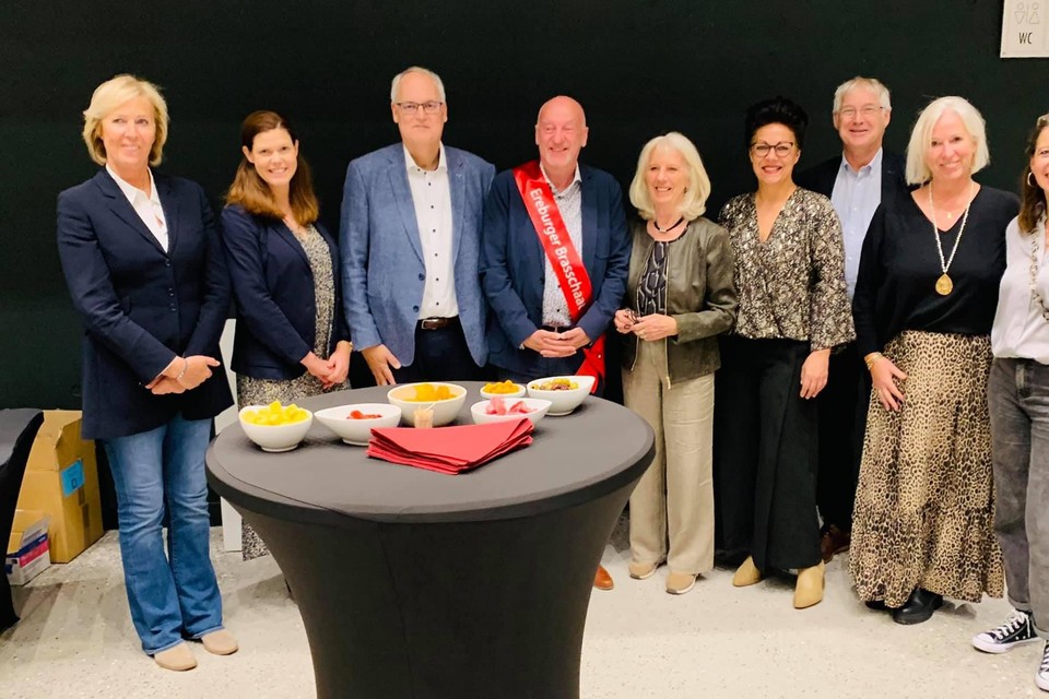 Paul Vande Casteele met lint en het voltallige gemeentebestuur.