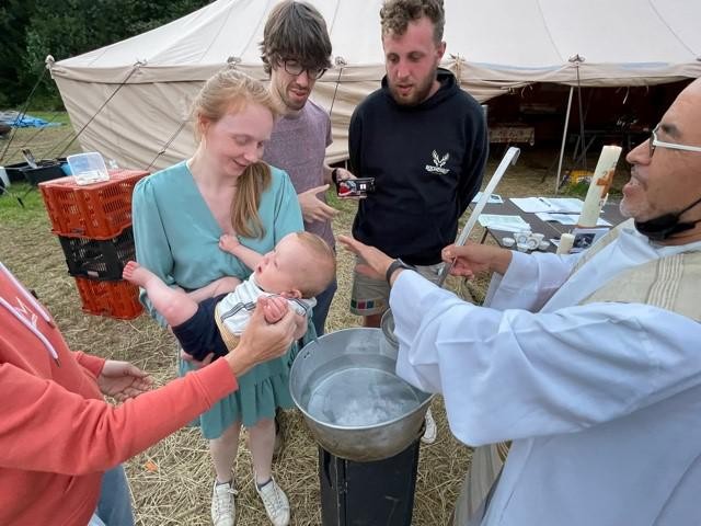 Pastoor Alvi, met op de achtergrond de doopkaars op tafel.