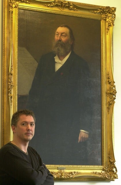 Jan Dewilde bij een schilderij van Peter Benoit in 2001, de honderdste verjaardag van zijn overlijden. 