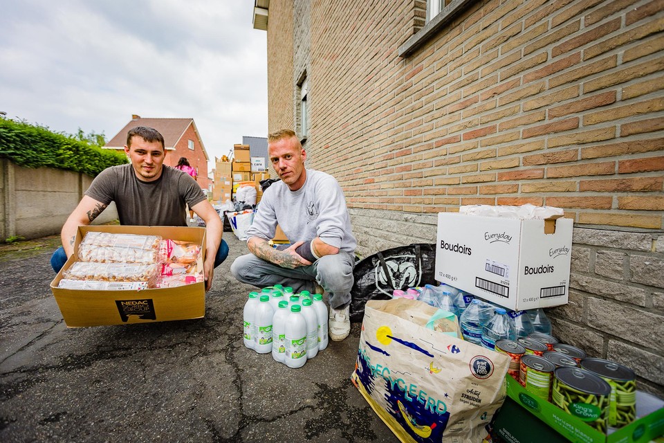 Kim Pelles en Bram Saele (met gips) tussen de ingezamelde hulpgoederen voor de inwoners van Pepinster.