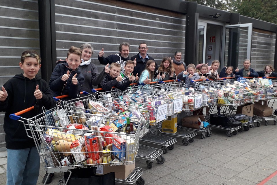 Vijfdejaars overhandigen ingezamelde voedsel aan De Schakel die zich inzet voor mensen met kleine portemonnee.