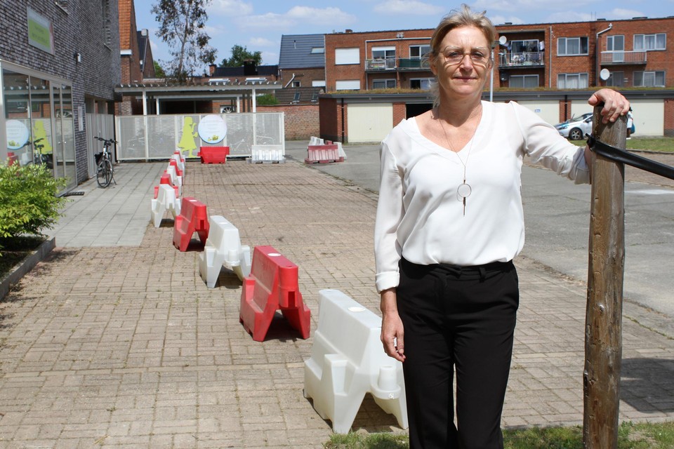 Schepen Ann Van Winkel staat aan de rood-witte new jerseys die de wandel- en fietszone afscheiden van de parkeerplaatsen en de rijweg.