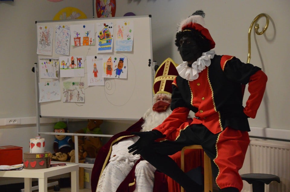 Sinterklaas en Zwarte Piet bij het bord met de mooiste tekeningen. 