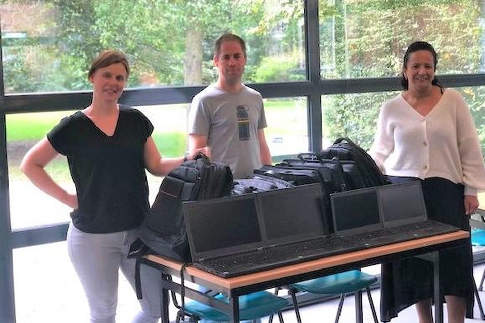 Ilse Verbruggen van De VoorZorg overhandigt de laptops aan Roel Noukens en Zineb El Boussaadani van J@M.