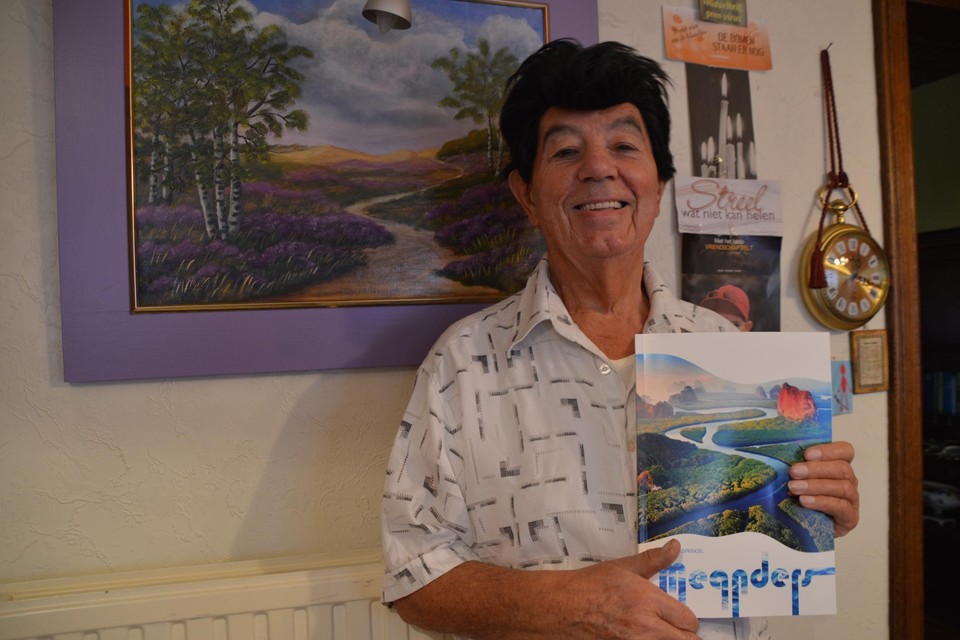 Theo Vanspringel met zijn boek Meanders voor een schilderij van de Belse Heide.