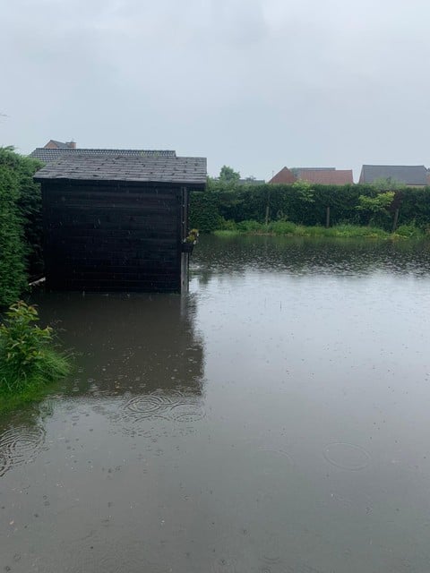 Na de regenbui van zaterdag in de vooravond stonden de tuinen van enkele woningen helemaal onder water.