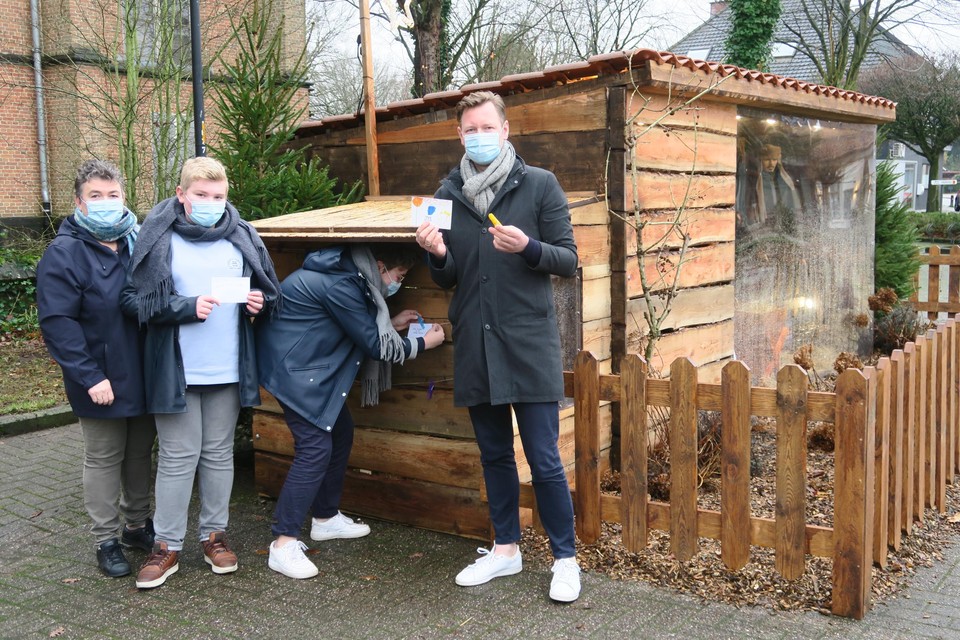 Gert Verhoeven met echtgenote Hilde Cox en kinderen Lien en Jasper bij de kerststal, waar Lien de eerste vredesboodschap aanhangt.