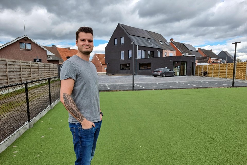 Elias Claessen op het kunstgras van de oefenruimte buiten. Op de achtergrond de nieuwe praktijk met ruime parking.