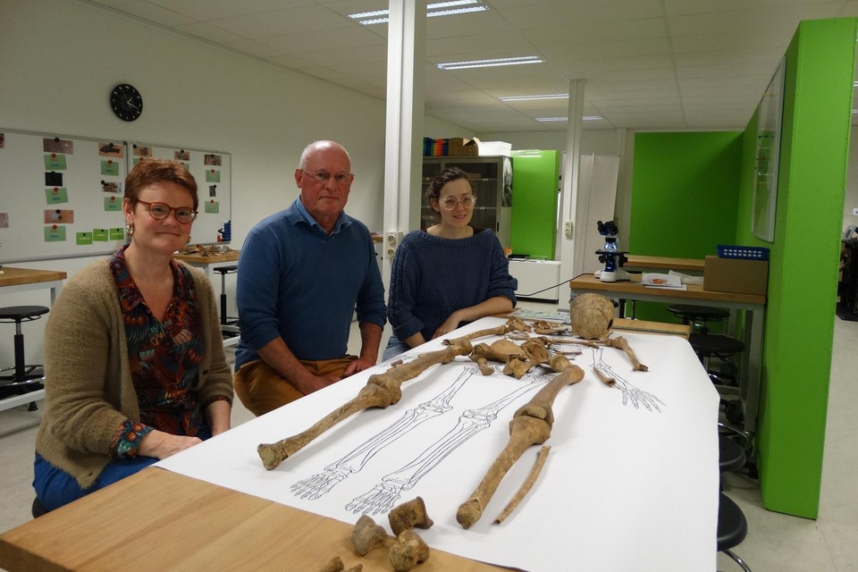 Coördinator Annick Elegheert, voorzitter Johan Smet en depotverantwoordelijke Els Tielemans stellen een uniek skelet van een monnik uit Boudelo tentoon.